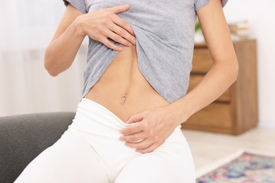 Photo of Woman with flat belly at home, closeup