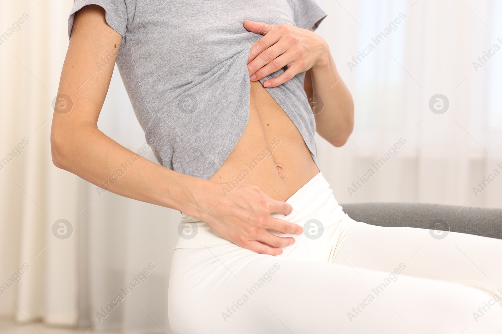 Woman with flat belly at home, closeup Photo of Woman with flat belly at home, closeup