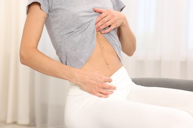 Photo of Woman with flat belly at home, closeup