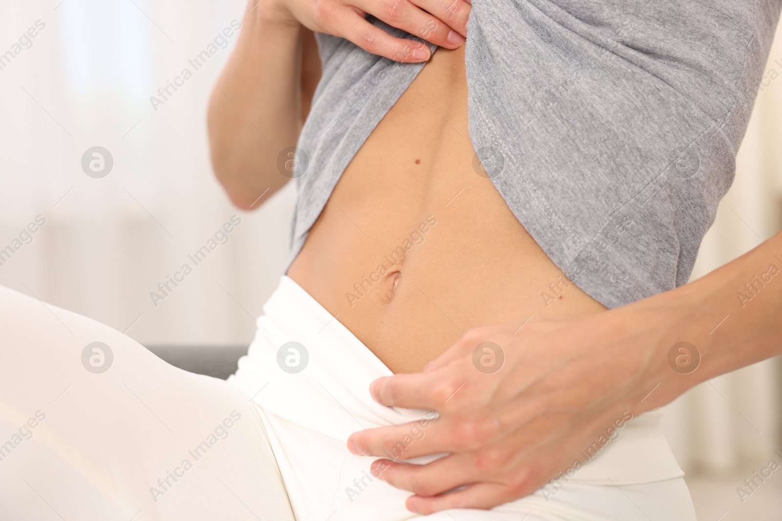 Woman with flat belly at home, closeup Photo of Woman with flat belly at home, closeup
