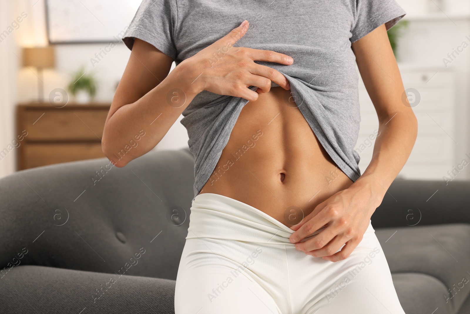 Woman with flat belly on sofa at home, closeup Photo of Woman with flat belly on sofa at home, closeup