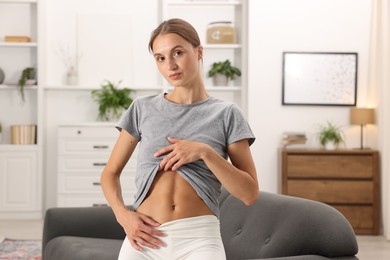 Photo of Woman with flat belly on sofa at home