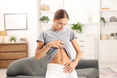 Photo of Woman with flat belly on sofa at home