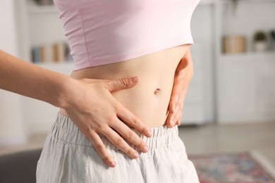 Photo of Woman with flat belly at home, closeup