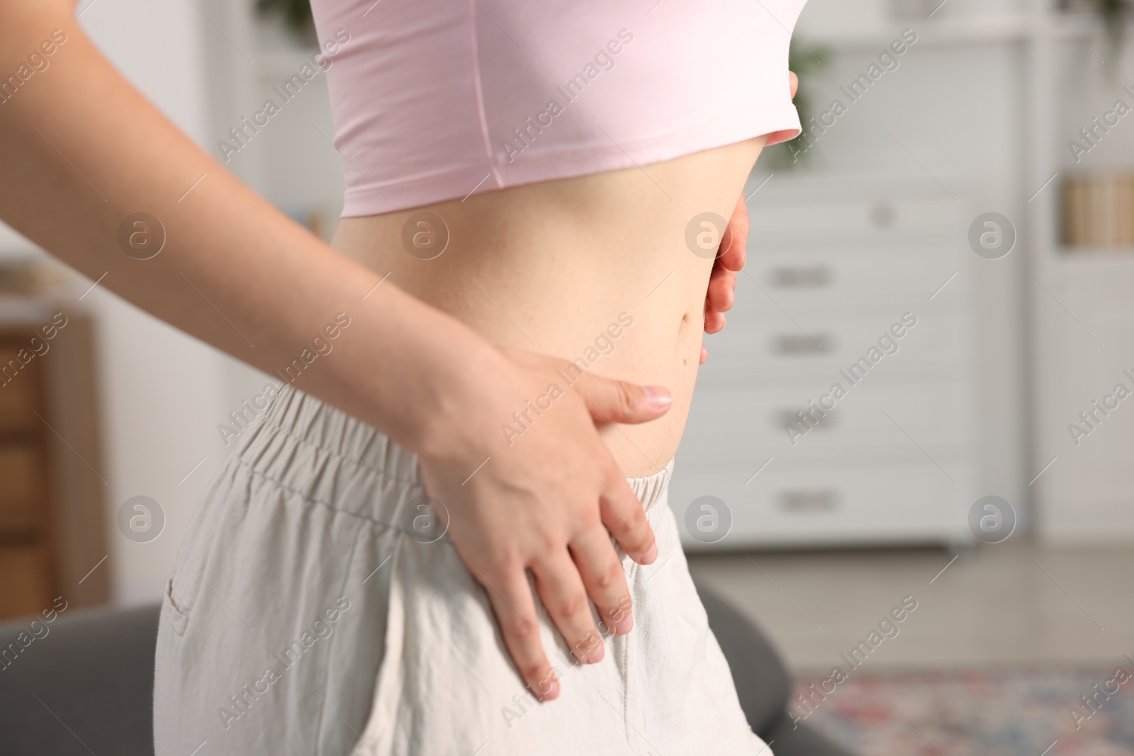 Woman with flat belly at home, closeup Photo of Woman with flat belly at home, closeup