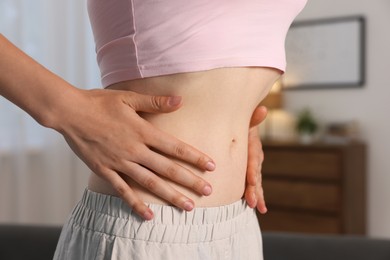 Photo of Woman with flat belly at home, closeup