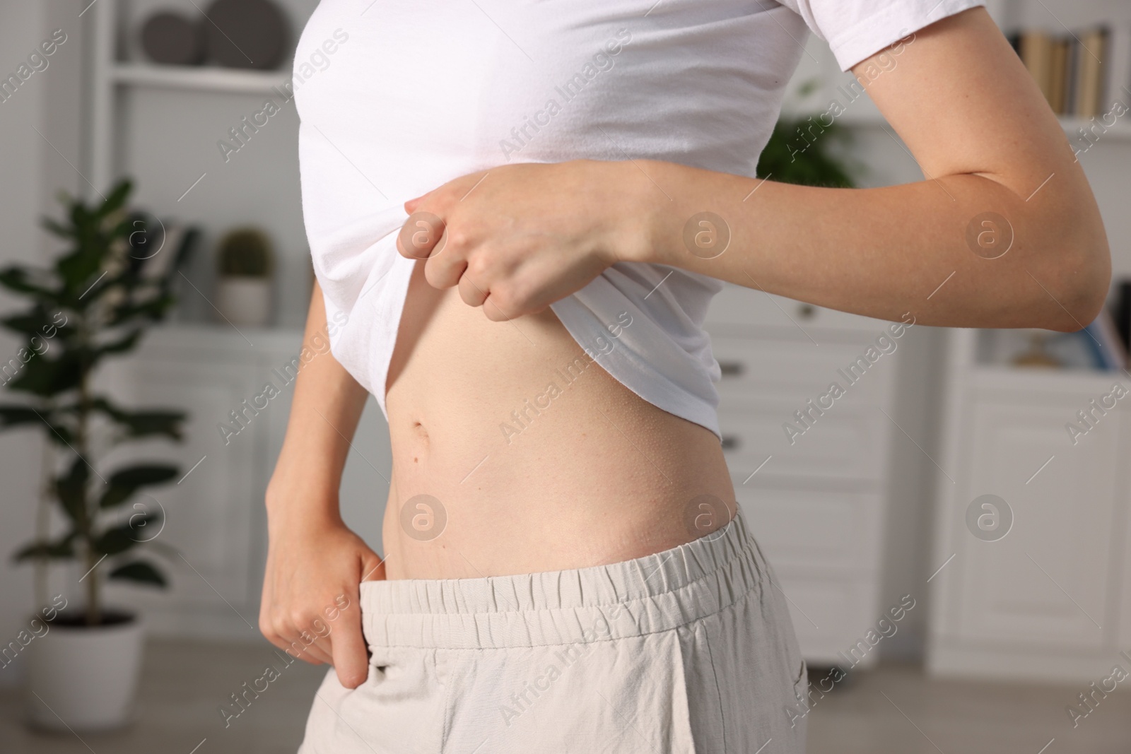 Woman with flat belly at home, closeup Photo of Woman with flat belly at home, closeup