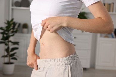 Photo of Woman with flat belly at home, closeup