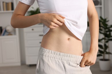 Photo of Woman with flat belly at home, closeup