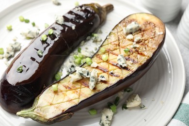 Photo of Slices of grilled eggplant with green onion and blue cheese on table