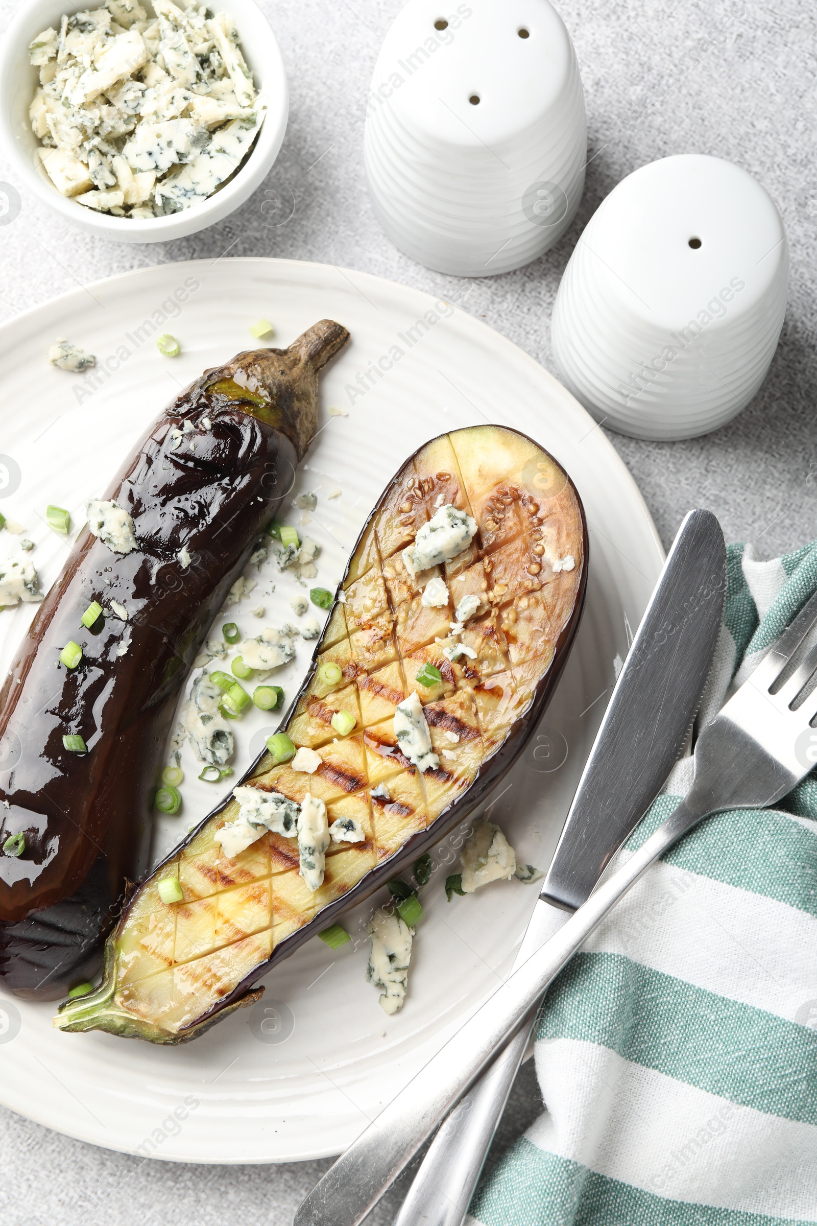 Slices of grilled eggplant with green onion and blue cheese on white table, flat lay Photo of Slices of grilled eggplant with green onion and blue cheese on white table, flat lay