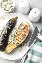 Photo of Slices of grilled eggplant with green onion and blue cheese on white table, flat lay