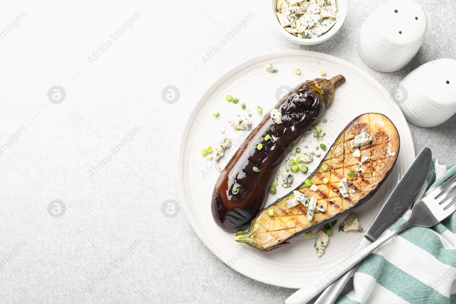 Slices of grilled eggplant with green onion and blue cheese on white table, flat lay. Space for text Photo of Slices of grilled eggplant with green onion and blue cheese on white table, flat lay. Space for text
