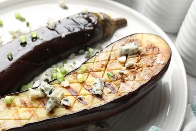 Photo of Slices of grilled eggplant with green onion and blue cheese on table