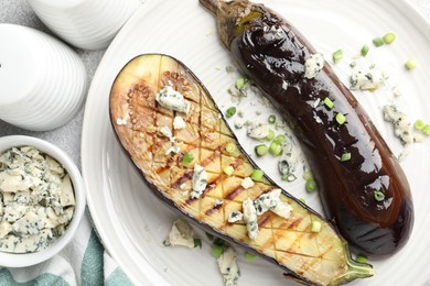 Photo of Slices of grilled eggplant with green onion and blue cheese on white table, flat lay