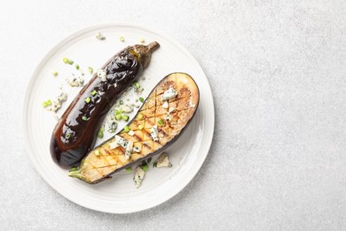 Photo of Slices of grilled eggplant with green onion and blue cheese on white table, top view. Space for text