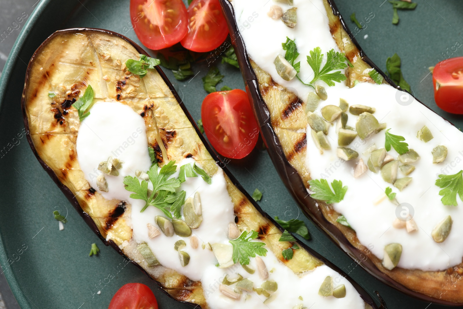 Photo of Slices of grilled eggplant with pumpkin seeds, tomatoes and yoghurt on table, top view