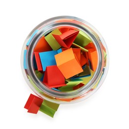 Photo of Many colorful paper pieces in glass isolated on white, top view