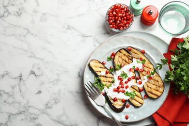 Photo of Slices of grilled eggplant with pomegranate seeds and yoghurt on white marble table, flat lay. Space for text
