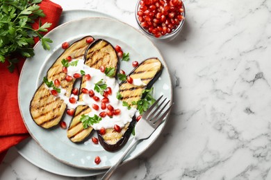 Photo of Slices of grilled eggplant with pomegranate seeds and yoghurt on white marble table, flat lay. Space for text