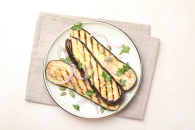 Photo of Slices of grilled eggplant, parsley, pumpkin seeds and onion on white table, top view