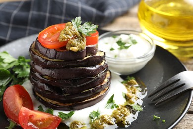 Photo of Tasty grilled eggplant slices with tomatoes, pesto and yoghurt on wooden table, closeup