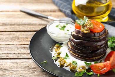 Photo of Tasty grilled eggplant slices with tomatoes, pesto and yoghurt on wooden table, closeup