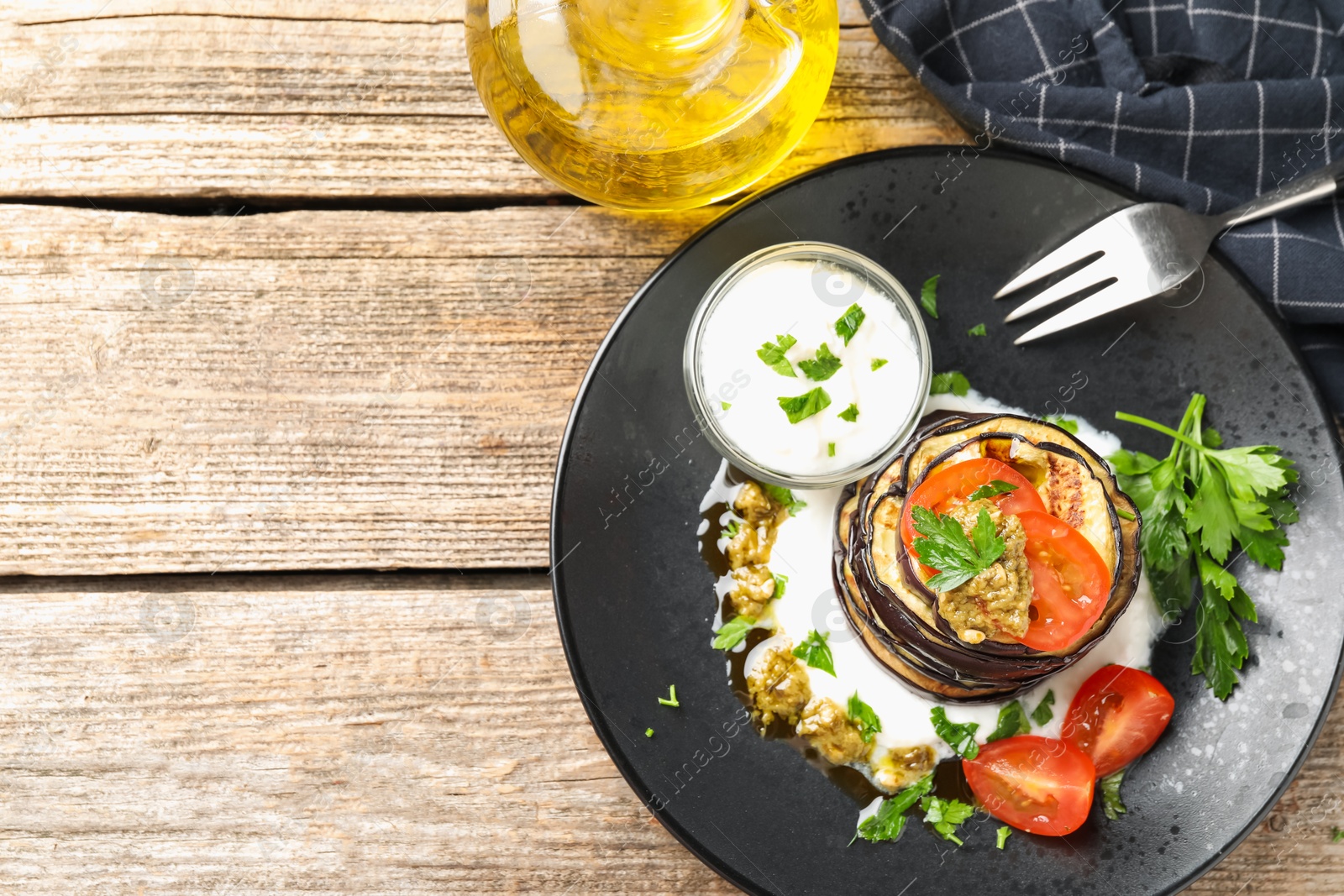 Tasty grilled eggplant slices with tomatoes, pesto and yoghurt on wooden table, flat lay. Space for text Photo of Tasty grilled eggplant slices with tomatoes, pesto and yoghurt on wooden table, flat lay. Space for text