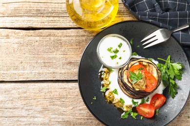 Photo of Tasty grilled eggplant slices with tomatoes, pesto and yoghurt on wooden table, flat lay. Space for text