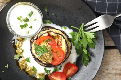 Photo of Tasty grilled eggplant slices with tomatoes, pesto and yoghurt on wooden table, top view