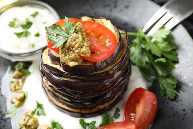 Photo of Tasty grilled eggplant slices with tomatoes, pesto and yoghurt on table, closeup