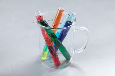 Photo of Test tubes with color liquids and beaker on light table