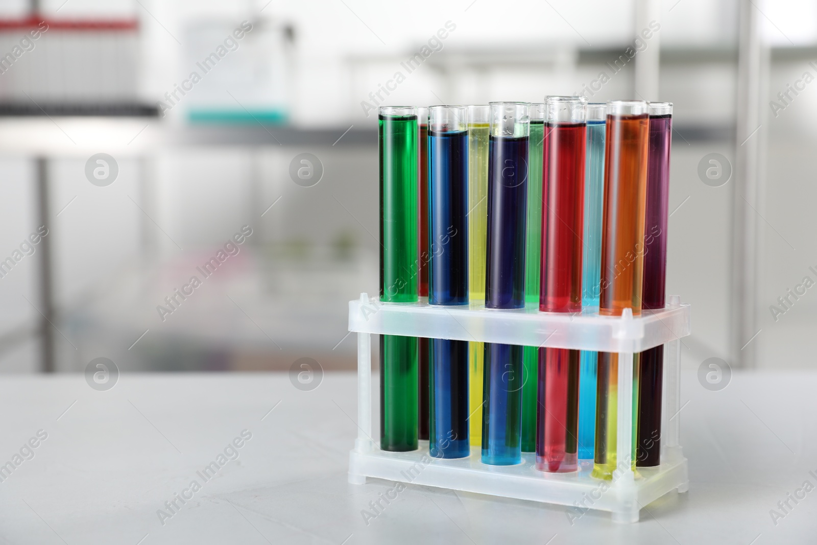 Test tubes with color liquids on light table in laboratory. Space for text Photo of Test tubes with color liquids on light table in laboratory. Space for text