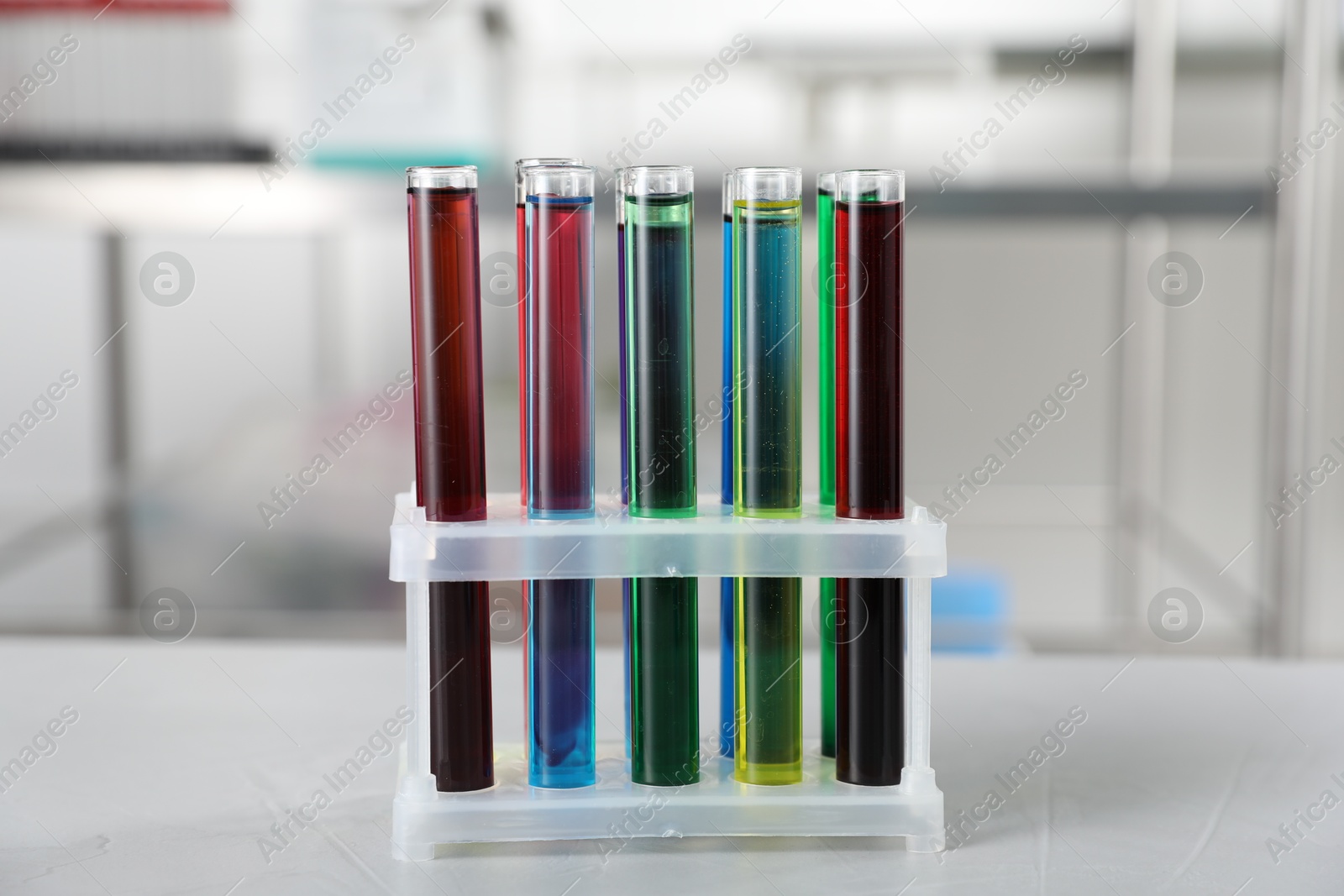Test tubes with color liquids on light table in laboratory Photo of Test tubes with color liquids on light table in laboratory