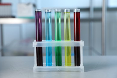 Photo of Test tubes with color liquids on light table in laboratory