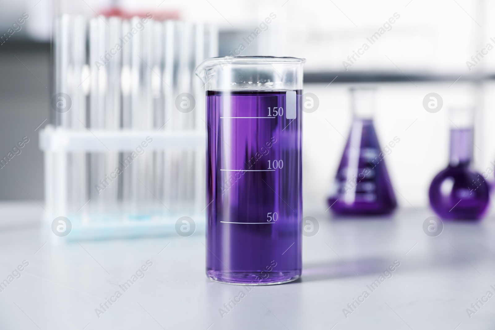 Different laboratory glassware with purple liquid on light table indoors, selective focus Photo of Different laboratory glassware with purple liquid on light table indoors, selective focus