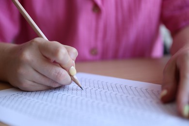 Photo of Student filling out multiple choice test at table, closeup. Passing exam