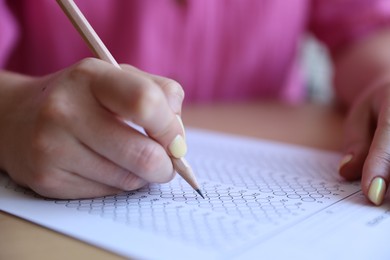 Photo of Student filling out multiple choice test at table, closeup. Passing exam