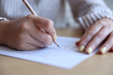 Photo of Student filling out multiple choice test at table, closeup. Passing exam