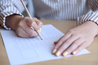 Photo of Student filling out multiple choice test at table, closeup. Passing exam