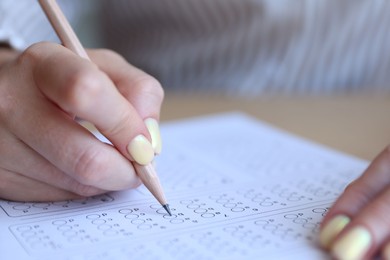 Photo of Student filling out multiple choice test at table, closeup. Passing exam
