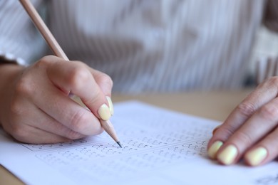 Photo of Student filling out multiple choice test at table, closeup. Passing exam
