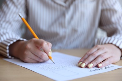 Photo of Student filling out multiple choice test at table, closeup. Passing exam