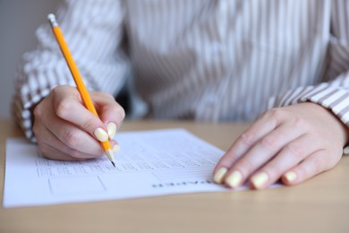Photo of Student filling out multiple choice test at table, closeup. Passing exam