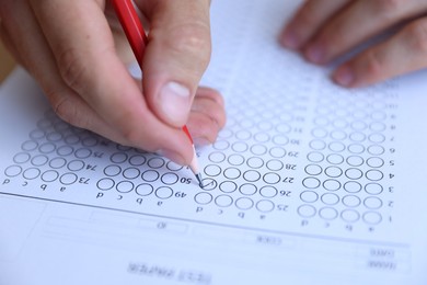 Photo of Student filling out multiple choice test, closeup. Passing exam