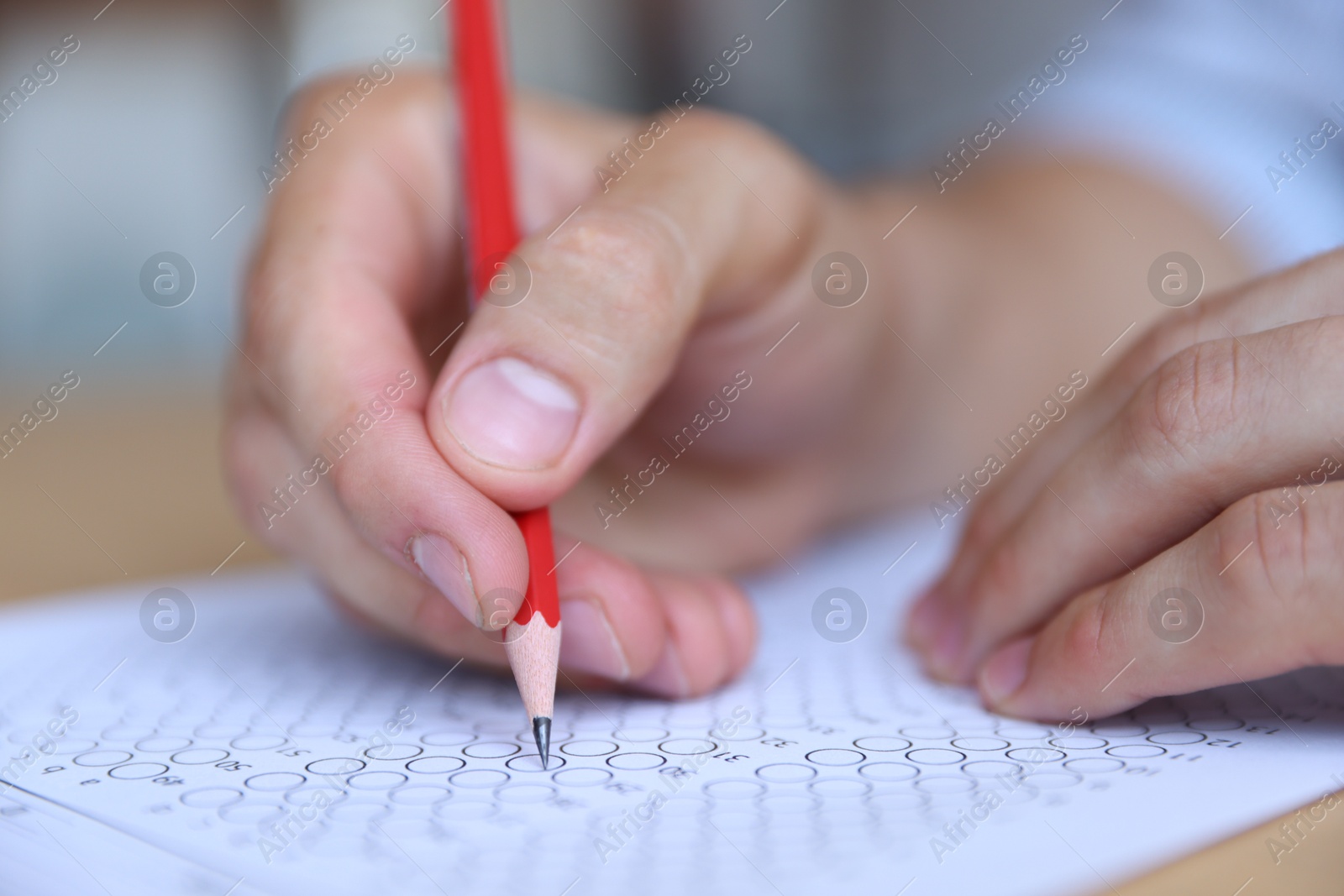 Student filling out multiple choice test at table, closeup. Passing exam Photo of Student filling out multiple choice test at table, closeup. Passing exam