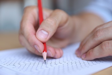 Photo of Student filling out multiple choice test at table, closeup. Passing exam