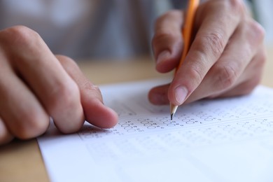 Photo of Student filling out multiple choice test at table, closeup. Passing exam