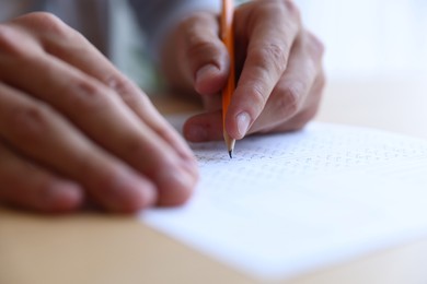Photo of Student filling out multiple choice test at table, closeup. Passing exam