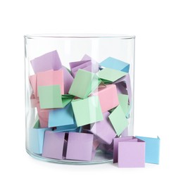 Photo of Many colorful paper pieces in glass isolated on white